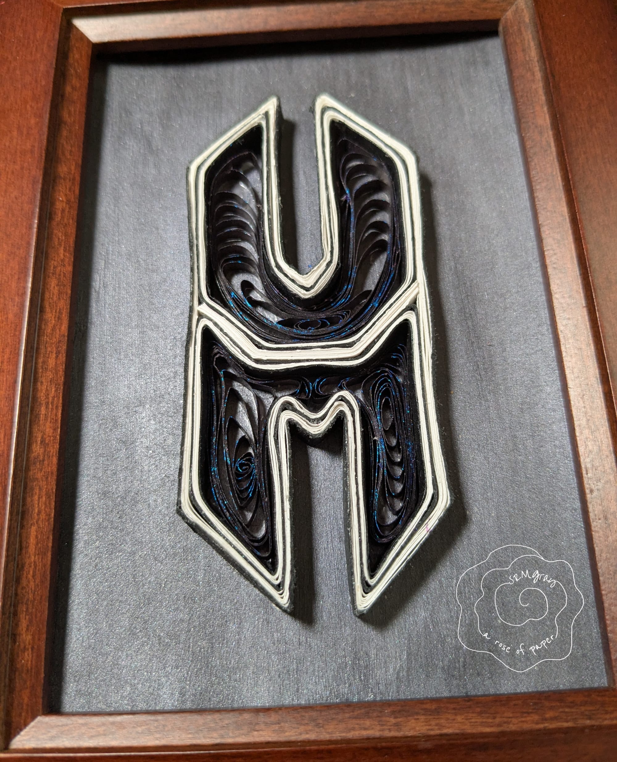 Confounded Machine logo rendered as hand-quilled paper art