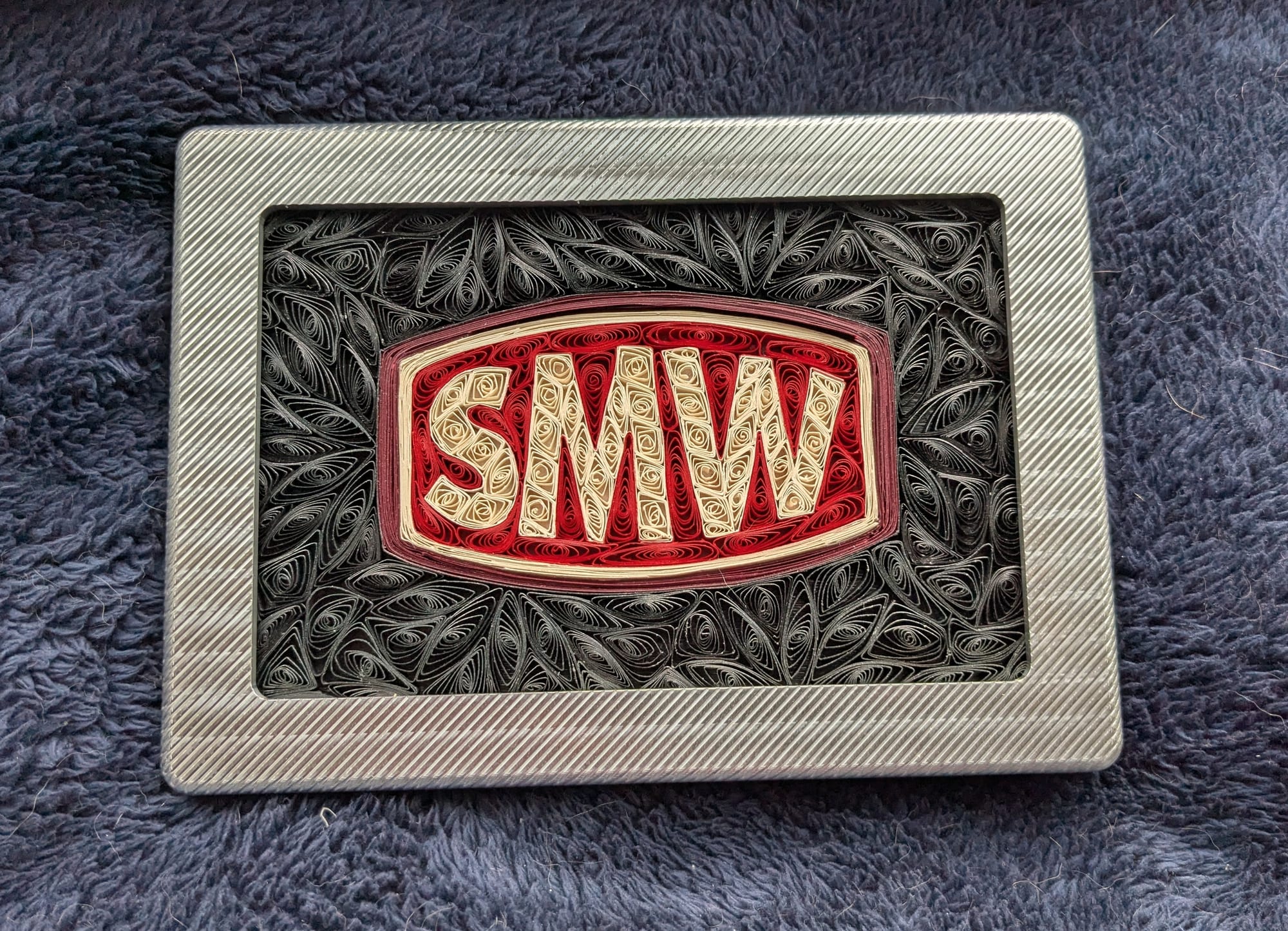 Saunders Machine Works logo as hand-quilled paper art